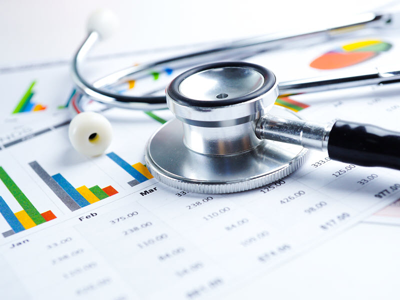 Stethoscope and banknotes on chart