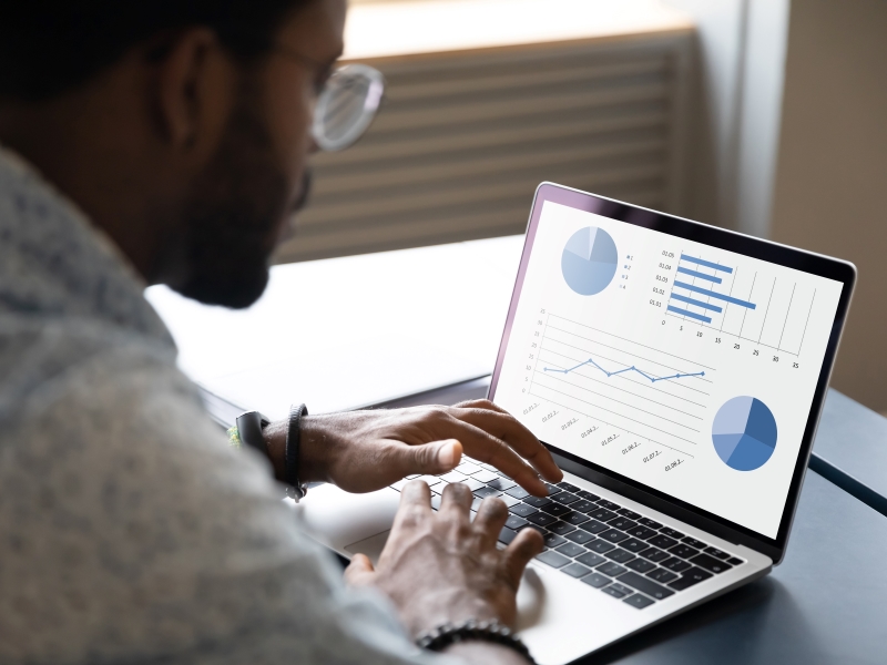 Consultant using laptop with benchmarking graphs on the screen