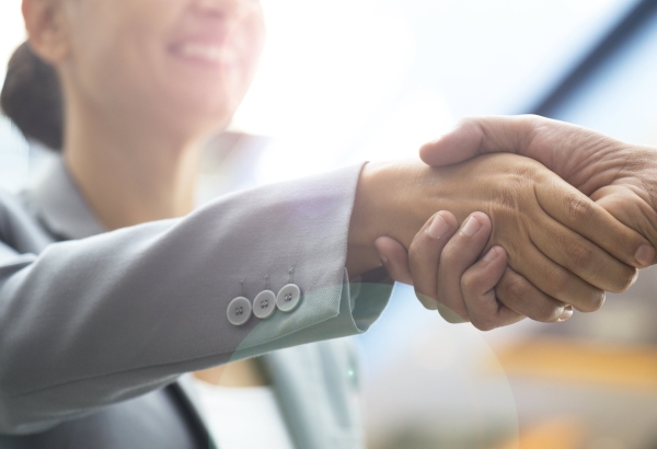Two business people shaking hands and smiling